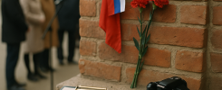 Tight close-up, photographic realism: the bronze memorial plaque at 68 Pushkina Street (ул. Пушкина,